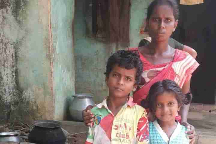 Woman stands with two children